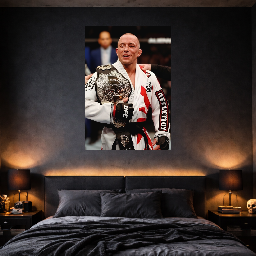 Man in a white martial arts uniform holding a championship belt above a bed with black bedding.