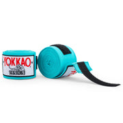 Turquoise hand wraps with Yokkao branding on a white background
