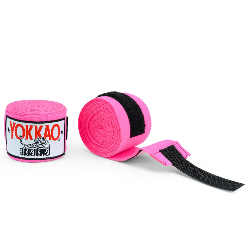 Pink hand wraps with black straps and Yokkao branding on a white background