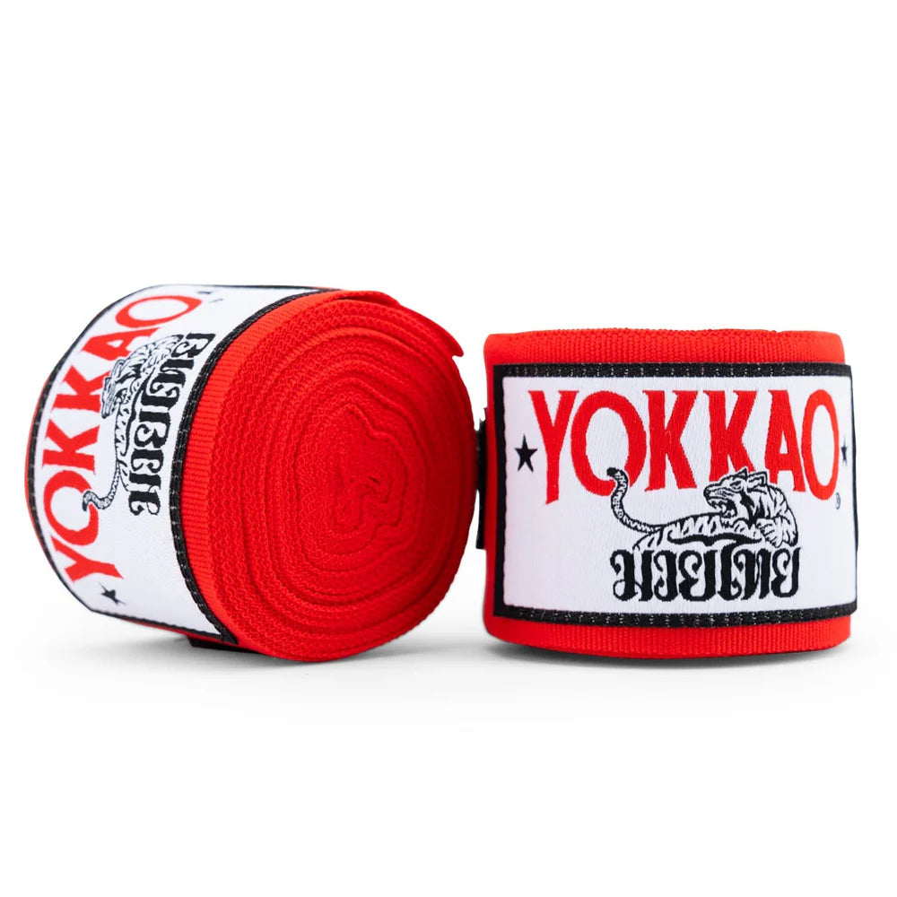 Red and white Yokkao branded boxing hand wraps on a white background