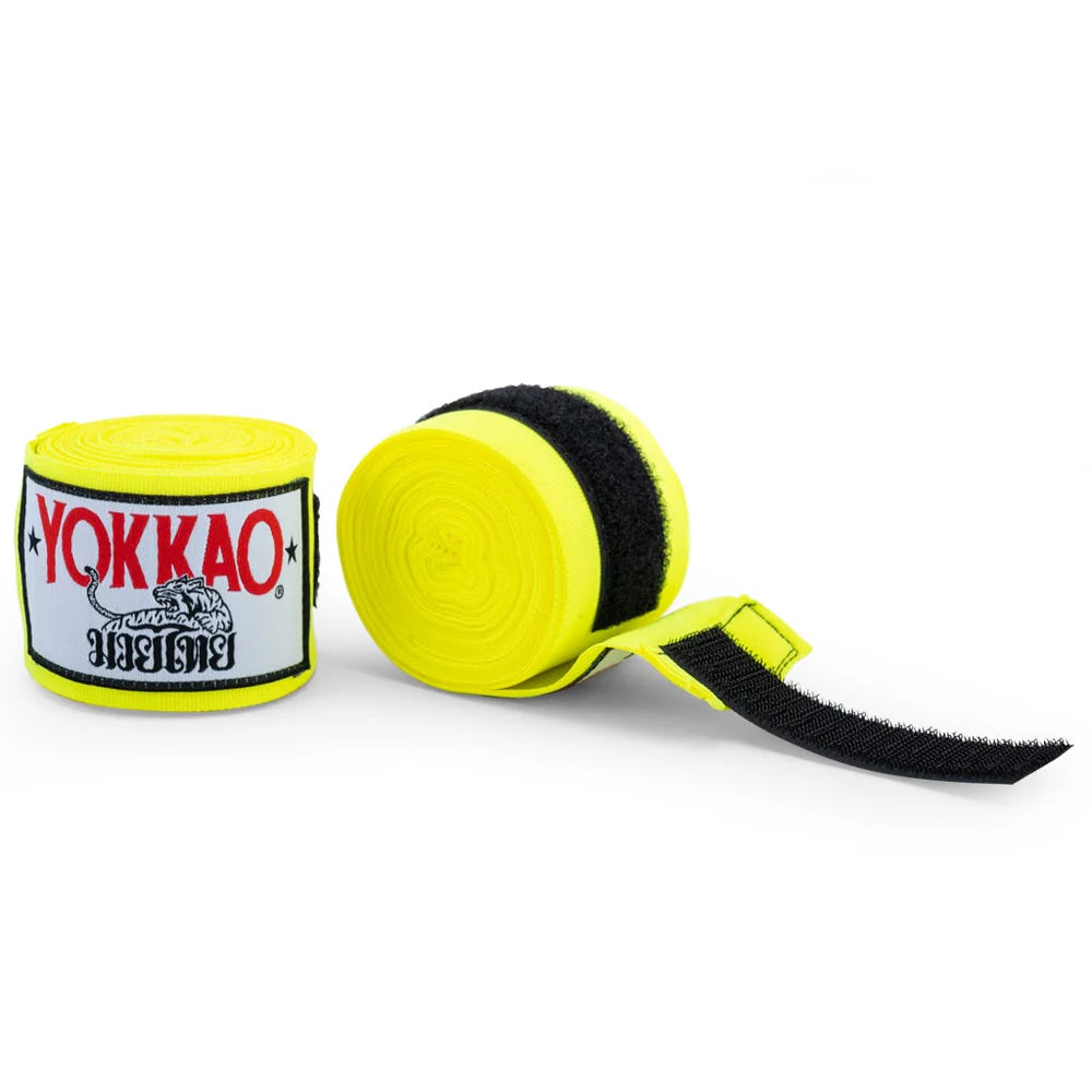 Yellow boxing hand wraps with black velcro strap and Yokkao branding on a white background