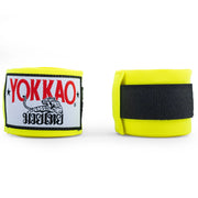 Yellow boxing hand wraps with Yokkao branding on a white background