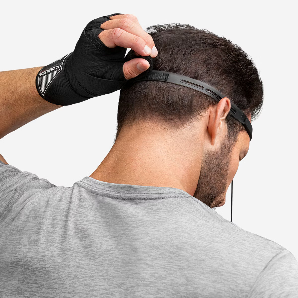 Person wearing a black headband with a gray shirt on a white background
