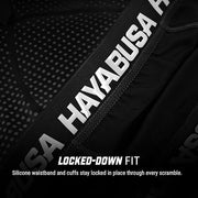 Close-up of a black garment with 'Hayabusa' branding and text about a locked-down fit.