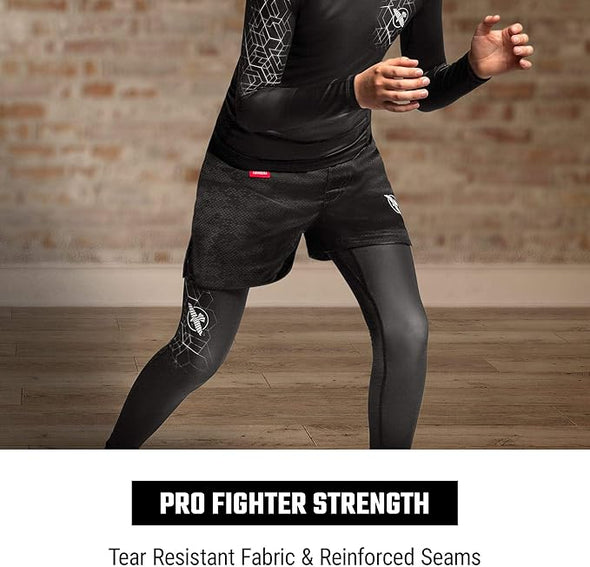 Person wearing black athletic compression gear with text 'Pro Fighter Strength' on a wooden floor.