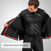 Person wearing a black martial arts gi with 'Hayabusa' branding, highlighting the 420-gsm pearl-weave cotton jacket.