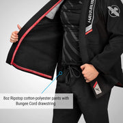 Person wearing a black martial arts uniform with visible branding on a gray background