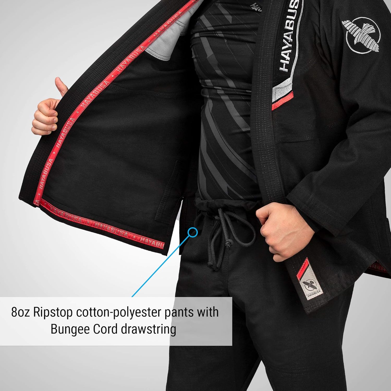 Person wearing a black martial arts uniform with visible branding on a gray background