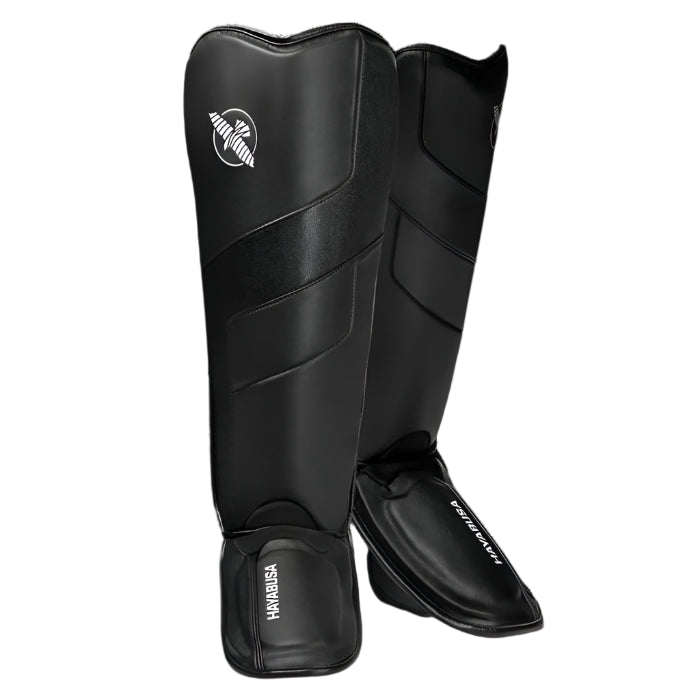 Pair of black shin guards with a brand logo on a white background