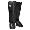 Pair of black shin guards with a brand logo on a white background