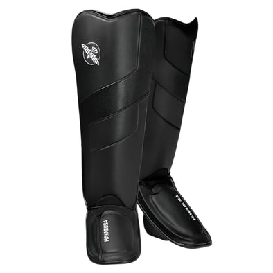 Pair of black shin guards with a brand logo on a white background