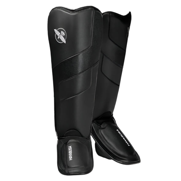 Pair of black shin guards with a brand logo on a white background