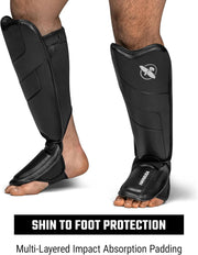 Black shin guards with impact absorption padding on a white background