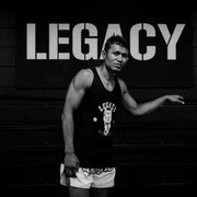 Person wearing a tank top with 'Legacy' branding in a gym setting