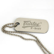 Metal dog tag with 'Fairtex F-Day' engraving on a white background