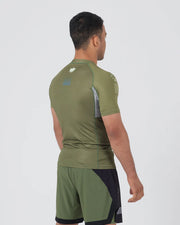Man wearing a green athletic outfit with visible branding on a white background