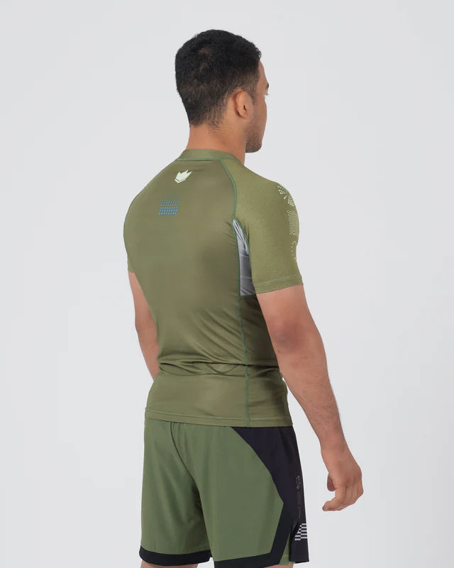 Man wearing a green athletic outfit with visible branding on a white background