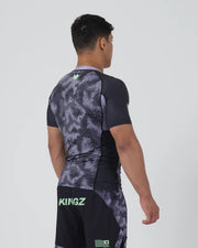 Person wearing a black and gray patterned athletic outfit with 'Kingz' branding on a white background