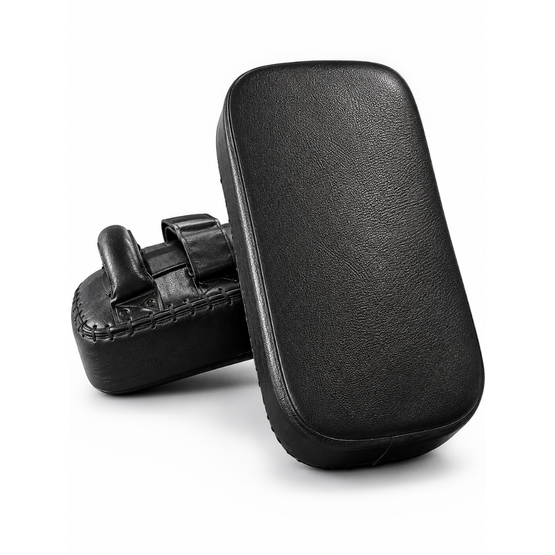 Black leather martial arts striking pads shown from two angles on a white background, one standing upright and the other lying on its side to show the strap attachment.