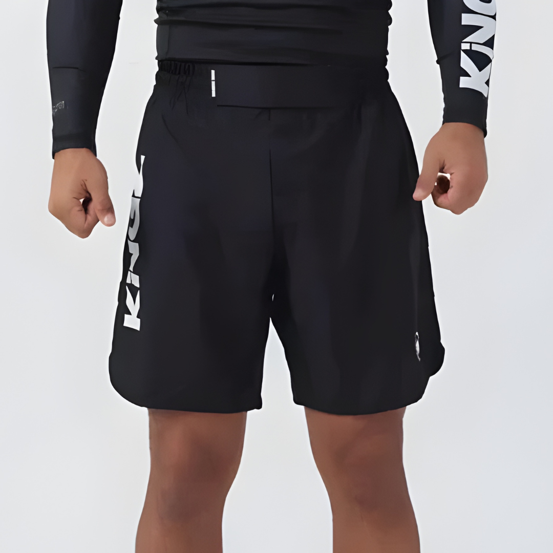 Person wearing black shorts with visible branding on a light gray background