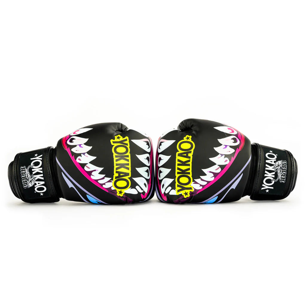 Pair of black boxing gloves with colorful shark design and 'Yokkao' branding on a white background.
