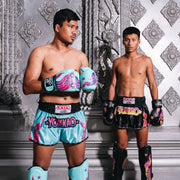 Two individuals wearing YOKKAO branded boxing gear against a decorative wall.