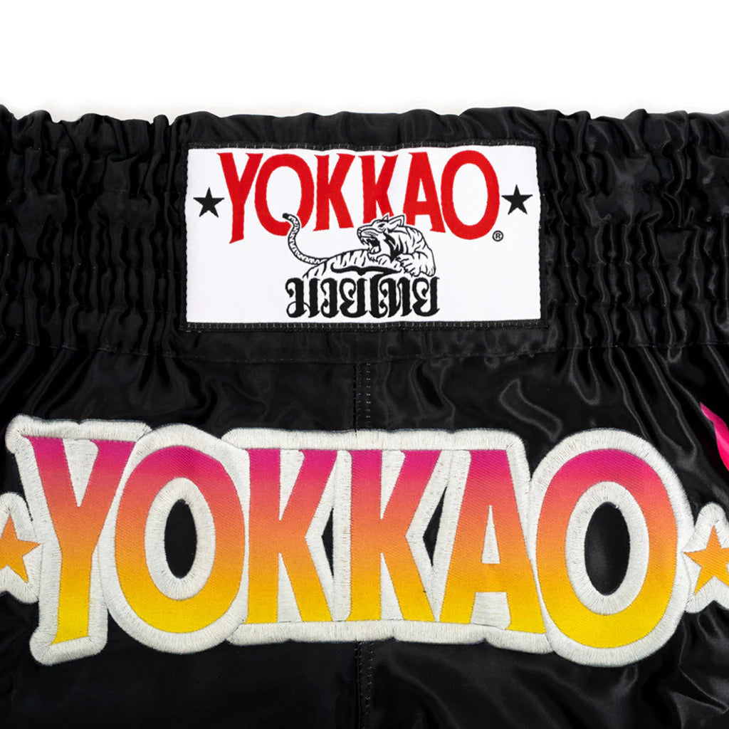 Black athletic shorts with colorful 'Yokkao' branding on a white background