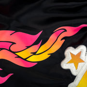 Black fabric with pink, orange, and yellow flames and a white star with a yellow center.