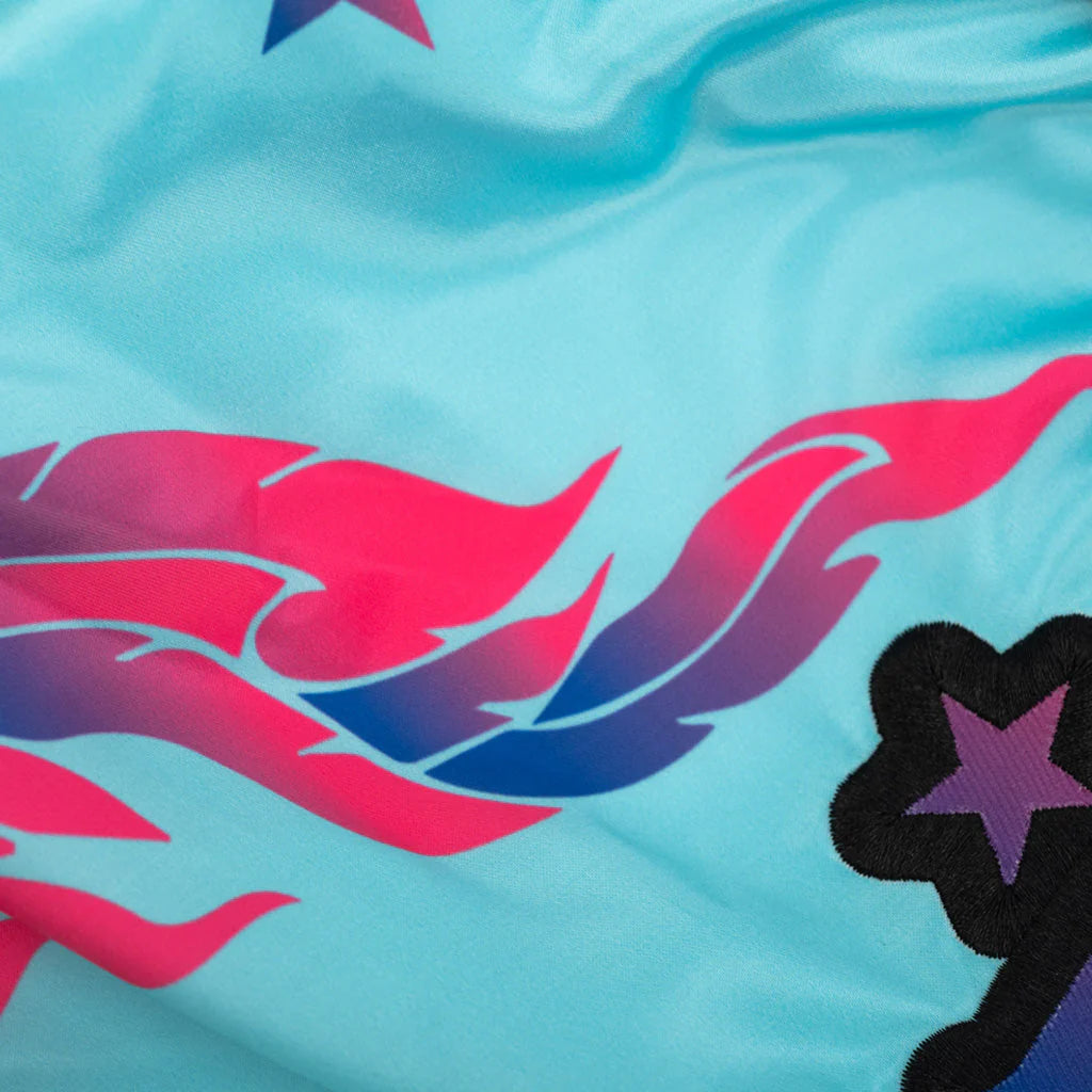 Close-up of a fabric with pink and blue abstract designs on a light blue background