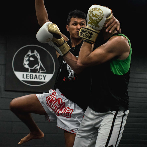 Two boxers in a sparring pose with 'Legacy' branding in the background