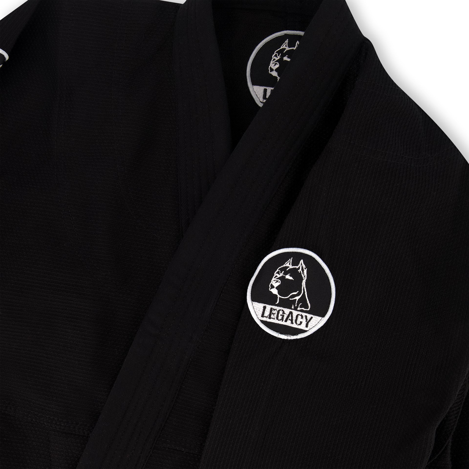 Official Team Legacy BJJ Gi in black, featuring a 450 GSM Pearl Weave Plus jacket, 10 oz cotton drill pants, reinforced stitching, and includes a white belt and drawstring bag.