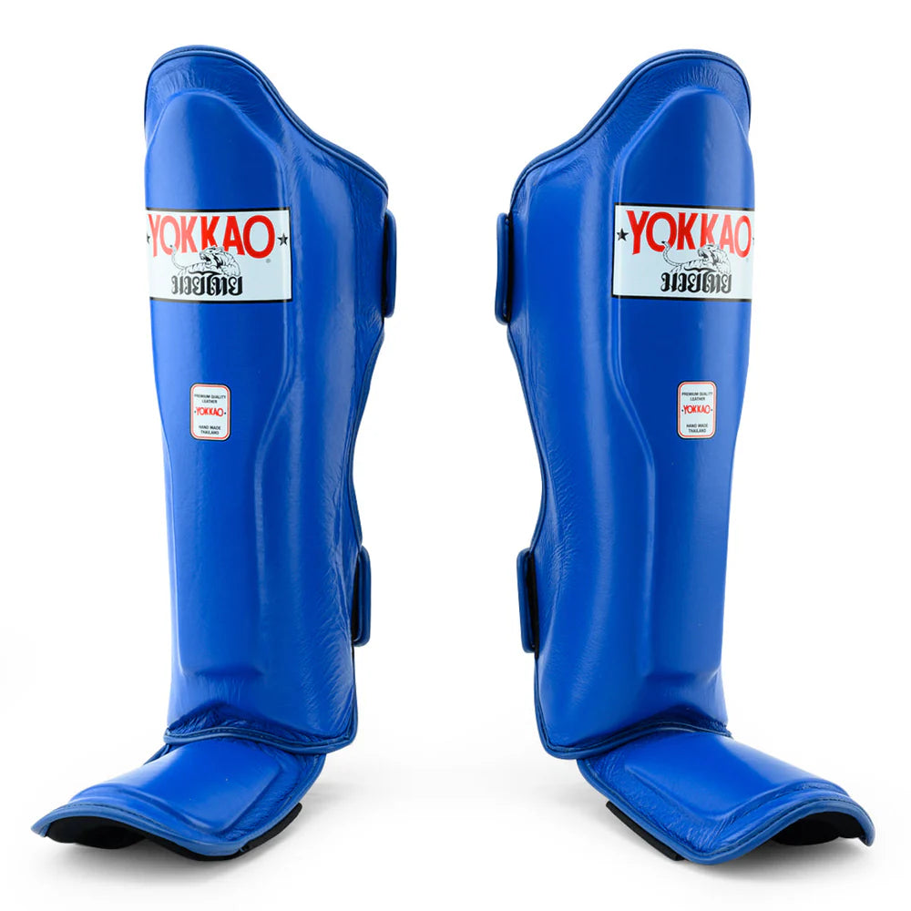 Pair of blue shin guards with Yokkao branding on a white background