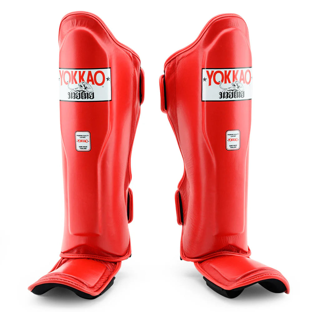 Red shin guards with Yokkao branding on a white background