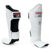 White shin guards with black accents and Yokkao branding on a white background