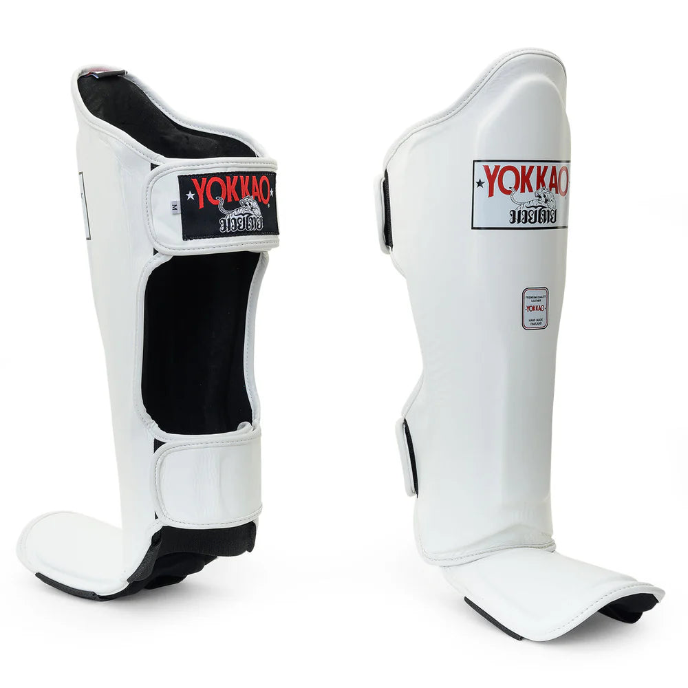 White shin guards with black accents and Yokkao branding on a white background