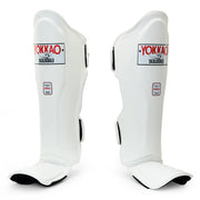 Pair of white Yokkao shin guards on a white background