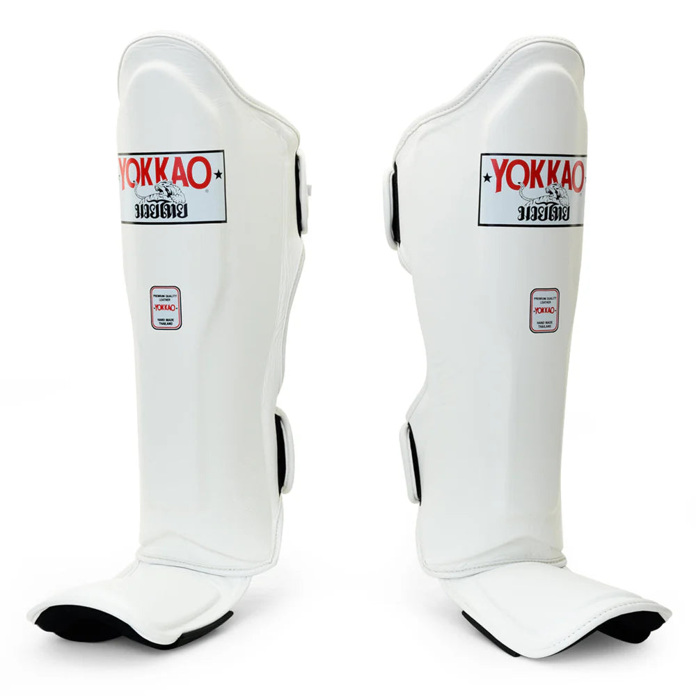 Pair of white Yokkao shin guards on a white background