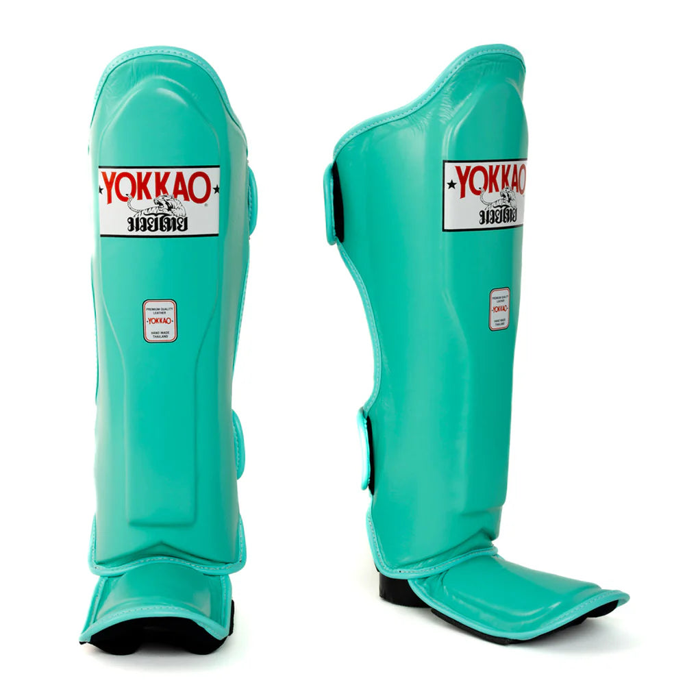 Turquoise shin guards with Yokkao branding on a white background