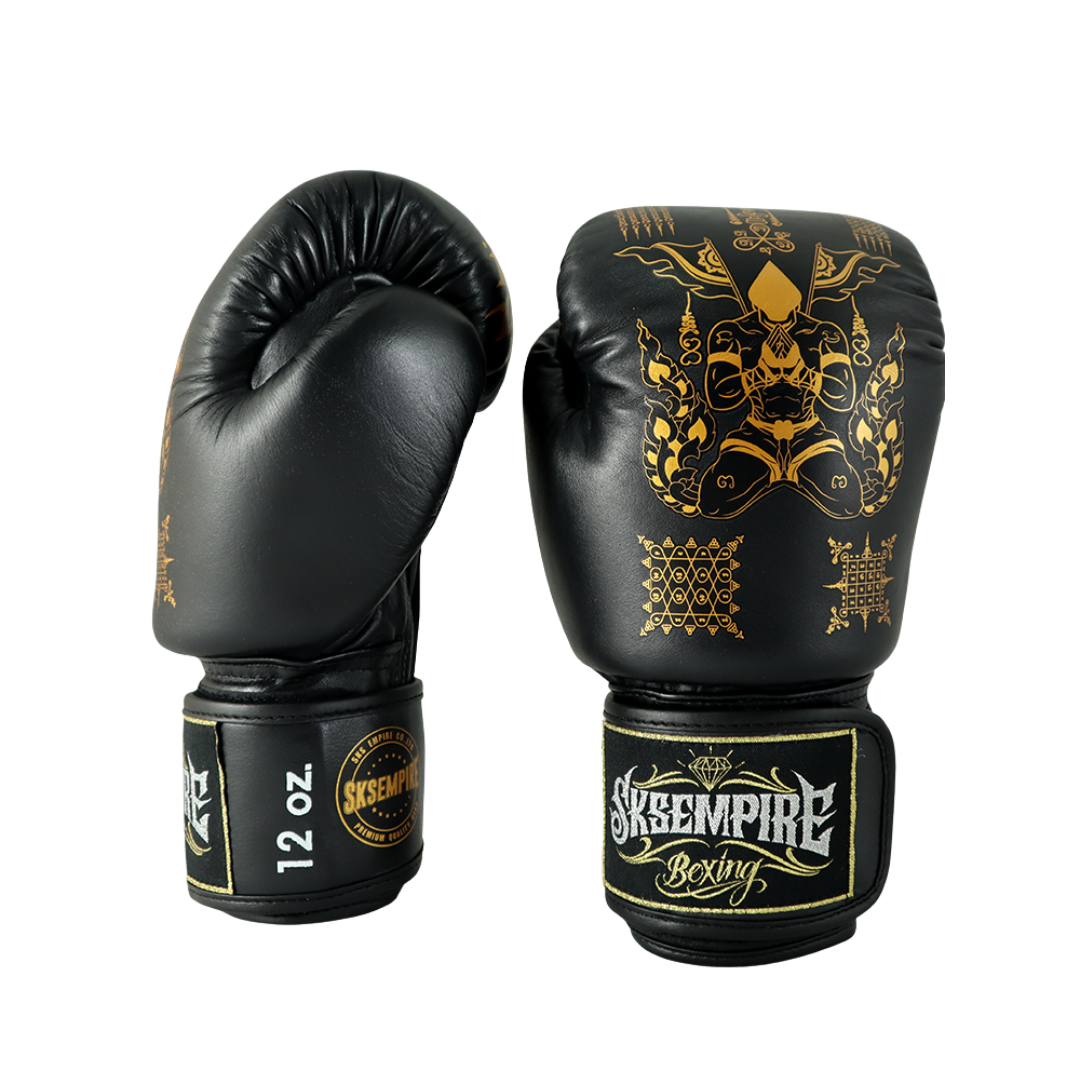 Black boxing gloves with gold designs and 'Skeempire Boxing' branding on a white background