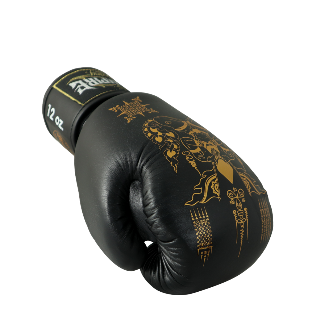 Black boxing glove with gold designs on a white background