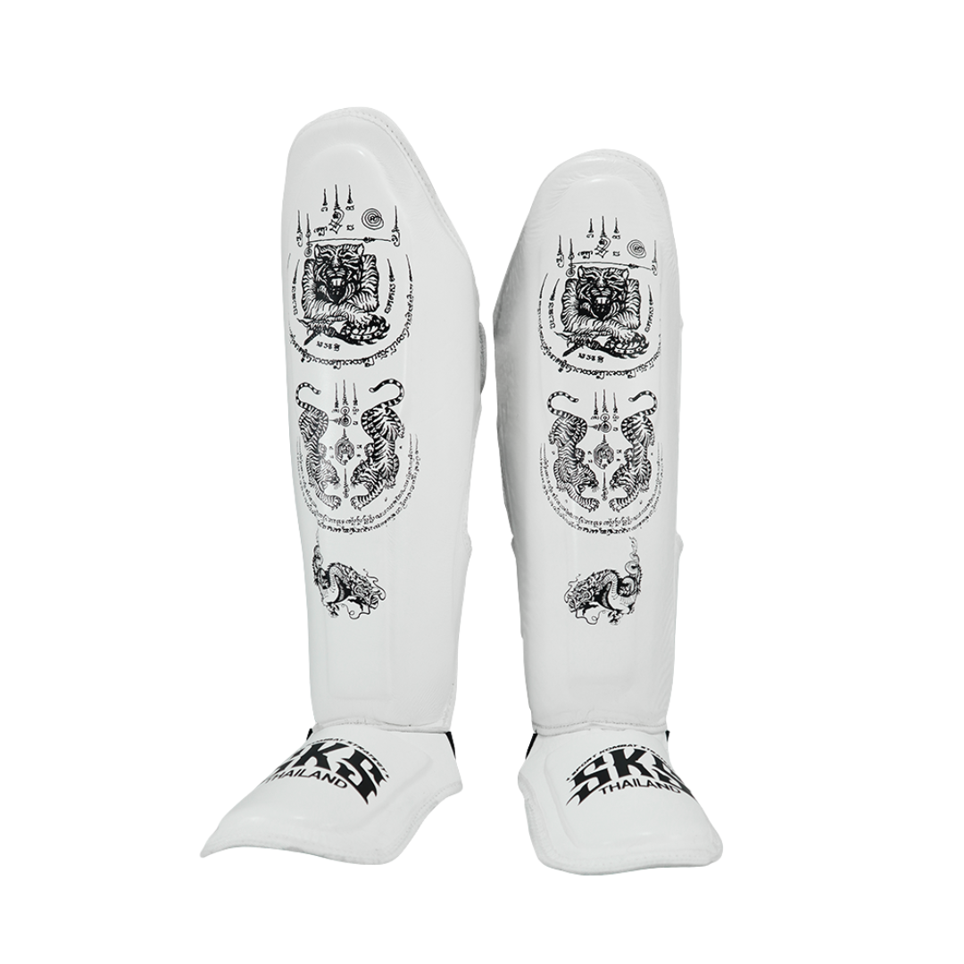 White shin guards with black designs and branding on a white background