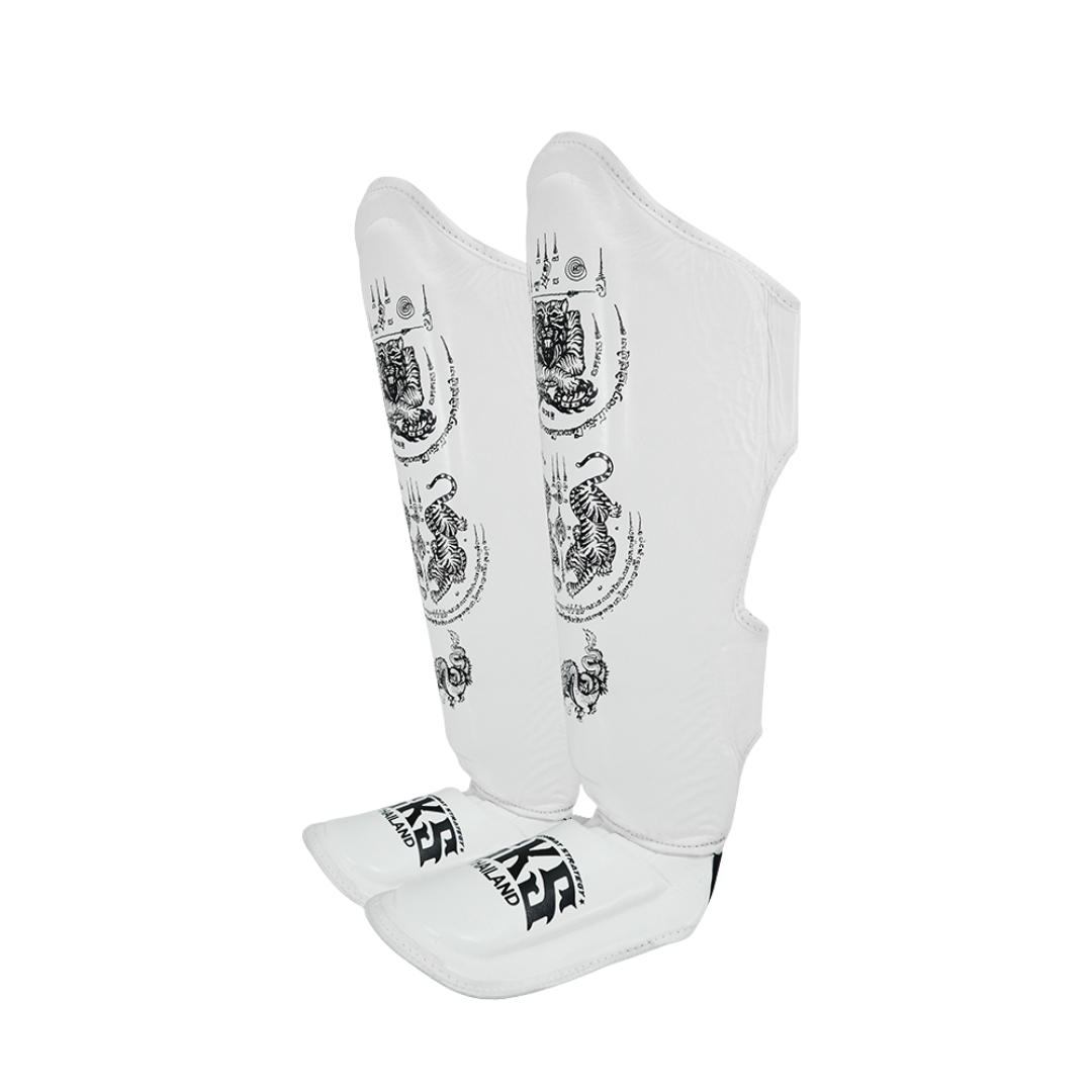 White shin guards with black patterns and branding on a white background