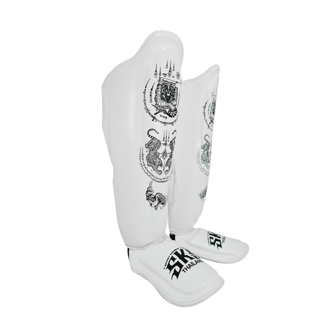 White shin guards with black patterns and branding on a white background