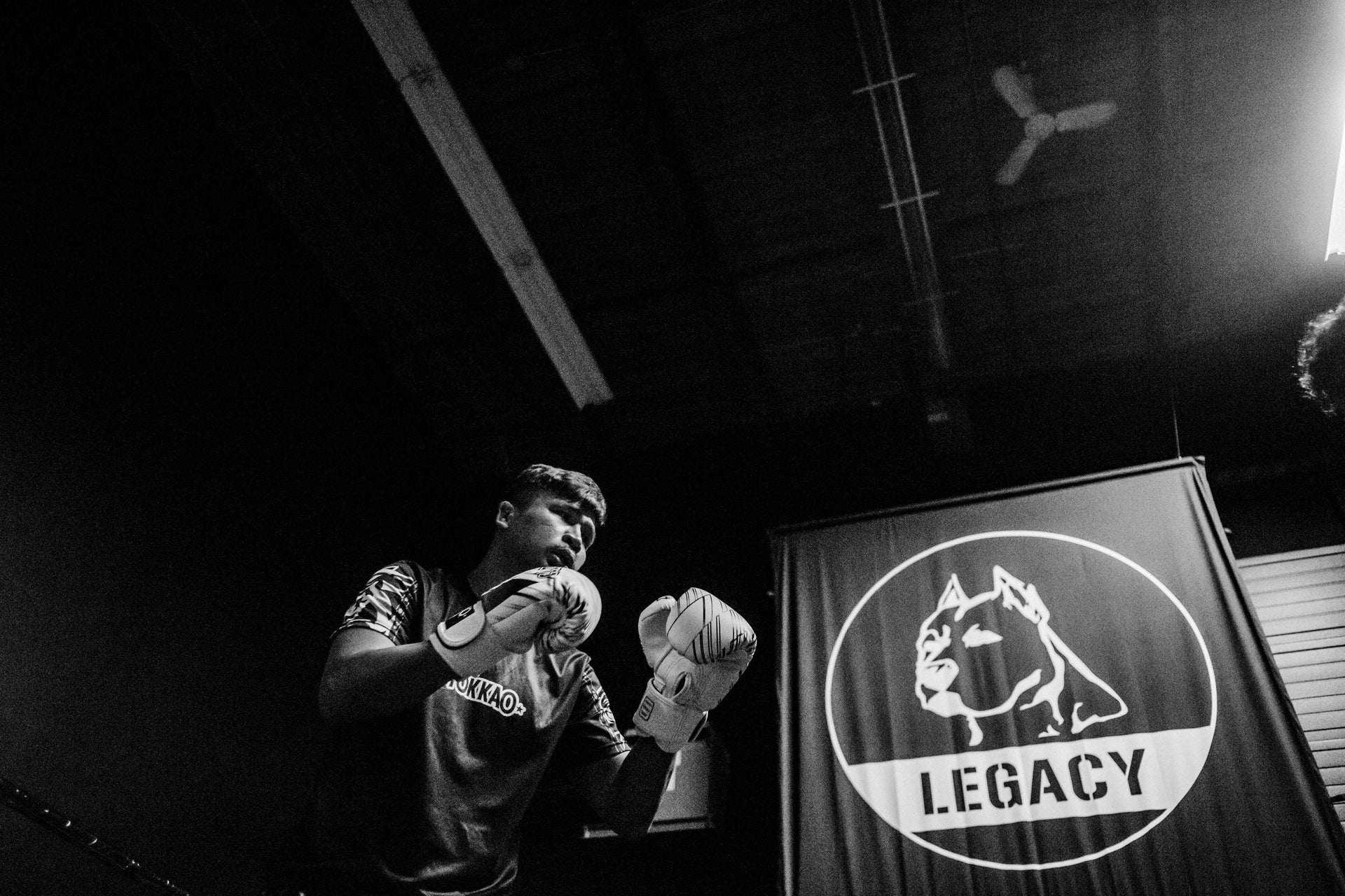 Person in boxing stance with 'Legacy' logo in the background