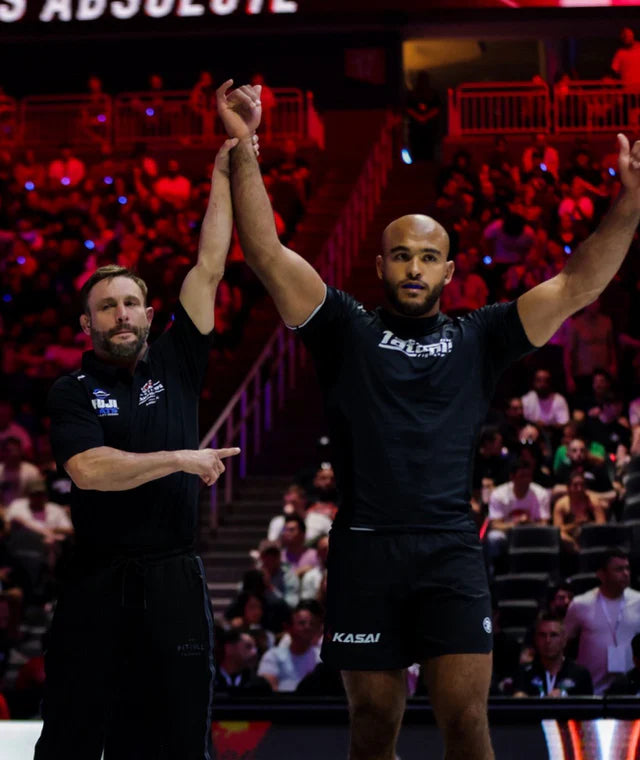 Two men in athletic wear celebrating on a sports court with a crowd in the background