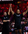 Two men in athletic wear celebrating on a sports court with a crowd in the background