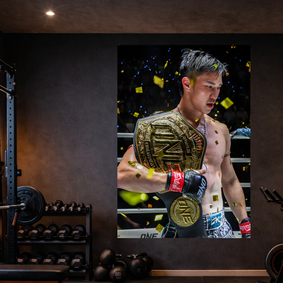 Boxer holding a championship belt in a gym setting