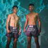 Two men wearing Yokkao boxing shorts against a textured blue background