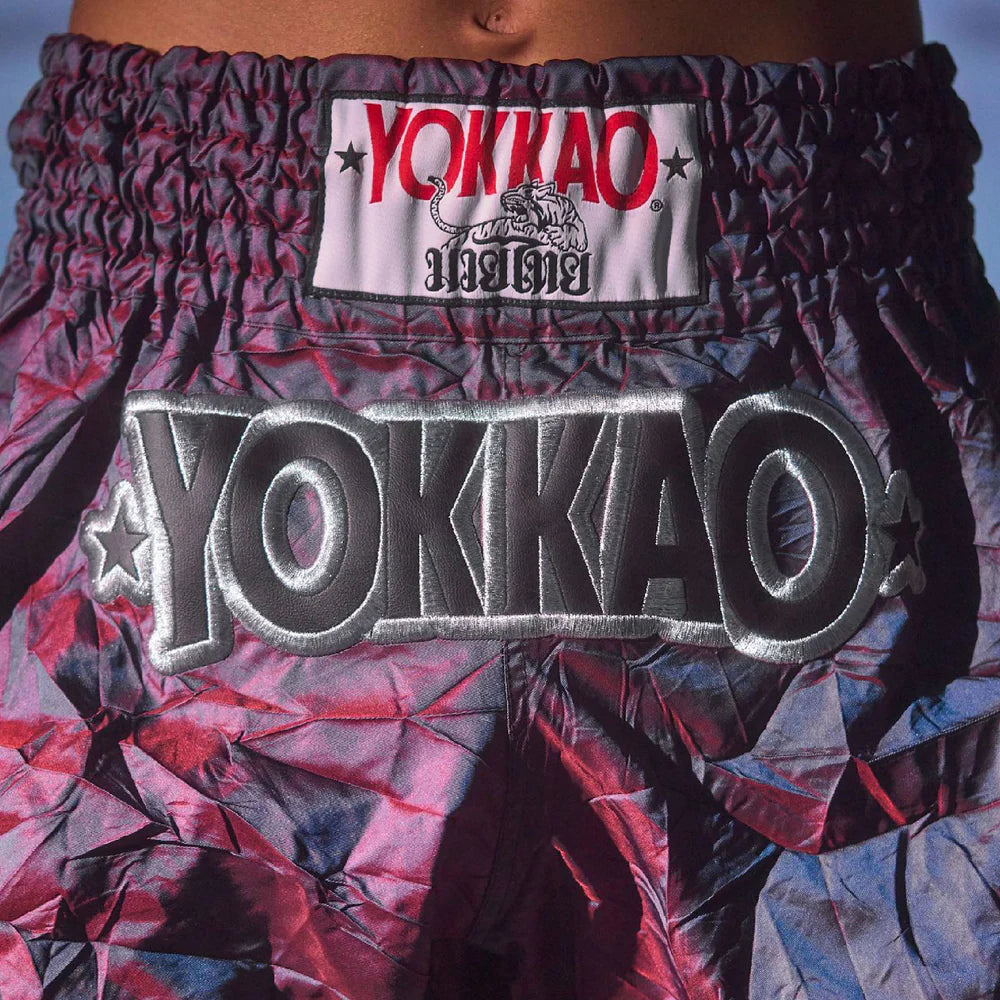 Close-up of YOKKAO branded boxing shorts with a colorful pattern.