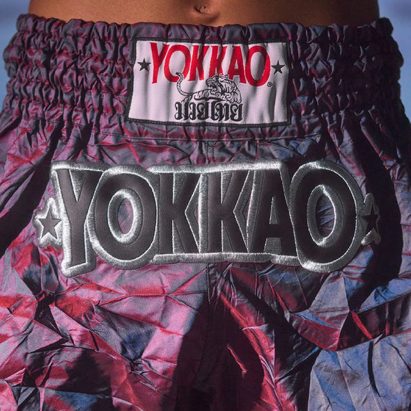 Close-up of YOKKAO branded boxing shorts with a colorful pattern.